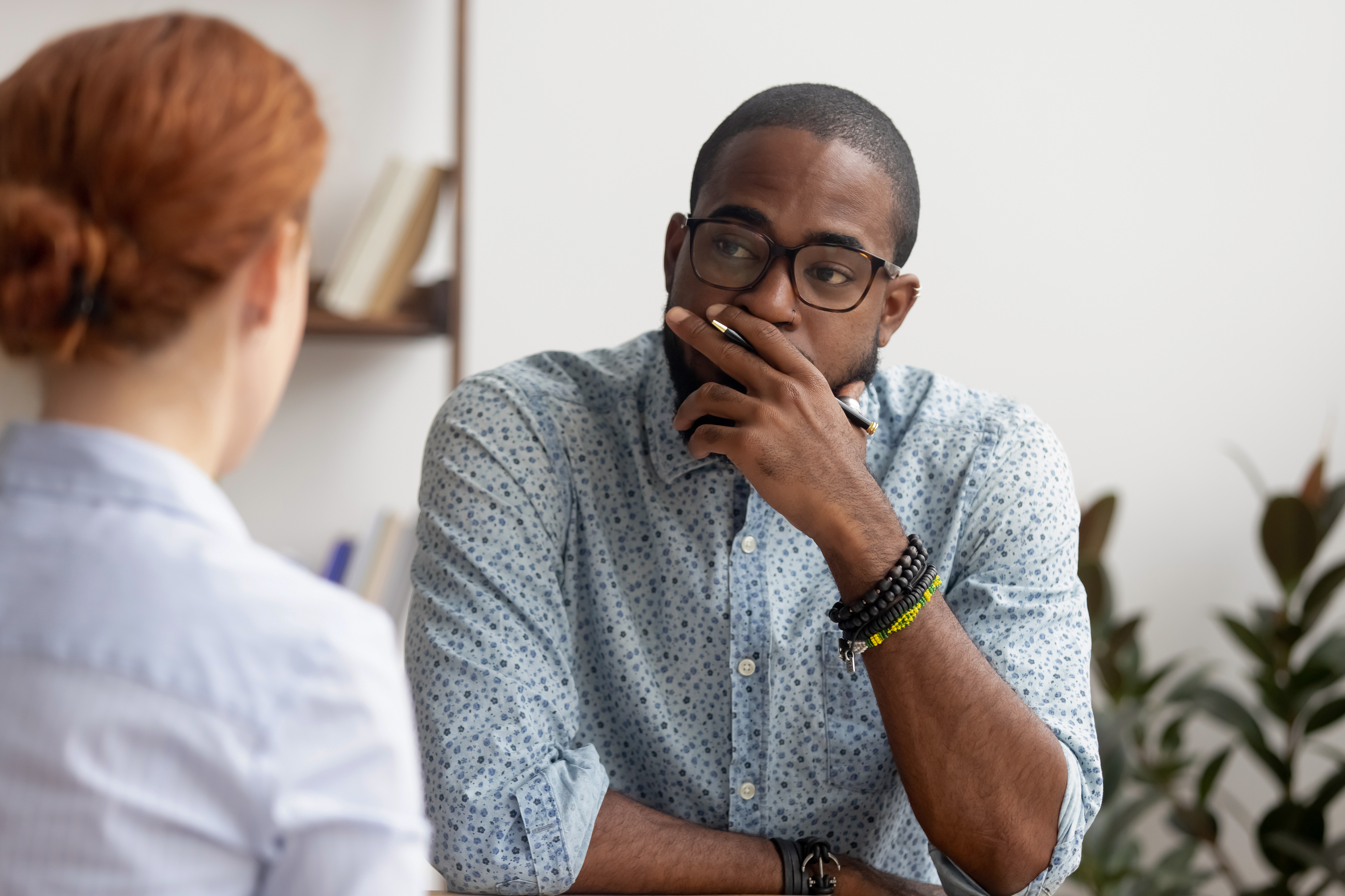 Doubtful unconvinced african american hr manager talking to caucasian applicant at job interview feeling skeptic rejecting seeker skill, bad first impression, lack of experience or failed performance