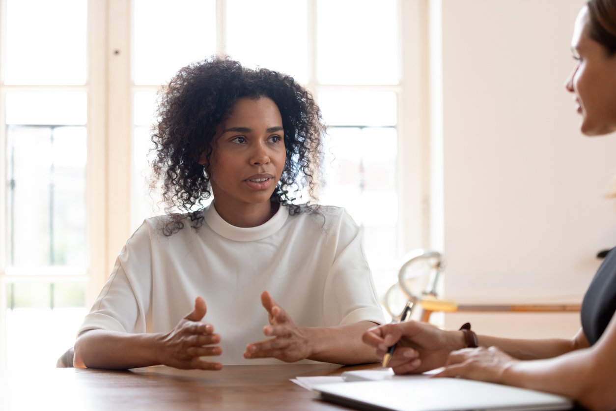 Concentrated African American female job applicant talk at job interview in office, focused confident biracial woman candidate speak negotiate with potential employer, hiring, recruitment concept