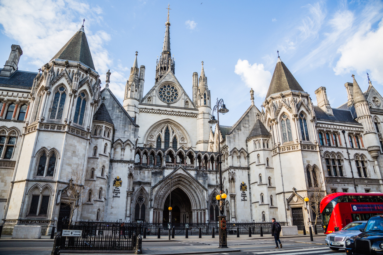 London,United Kingdom-26 March 2018:Some people crossing the road in front of the Palace of the Royal Courts of Justice